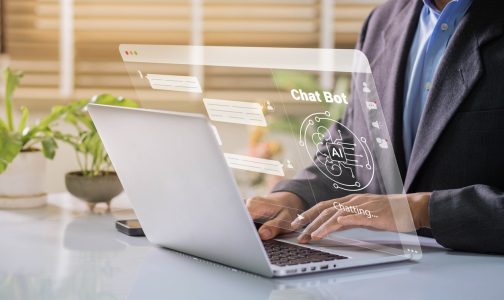 Business hands typing on keyboard with AI and search interface overlay, symbolising AI-driven SEO strategy